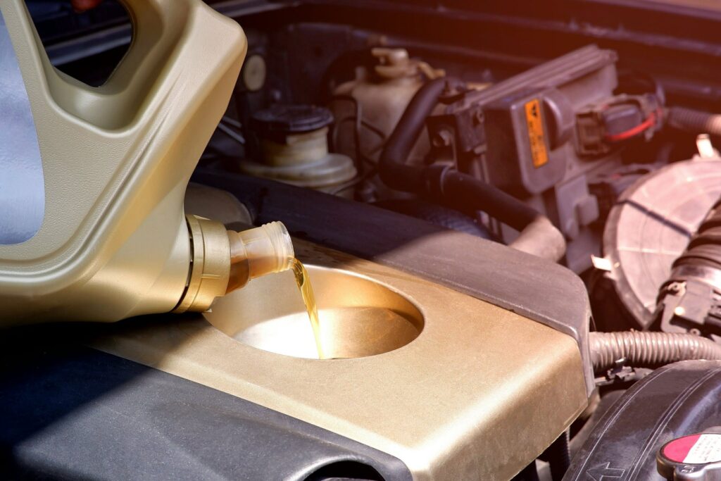 Pouring engine oil into car engine