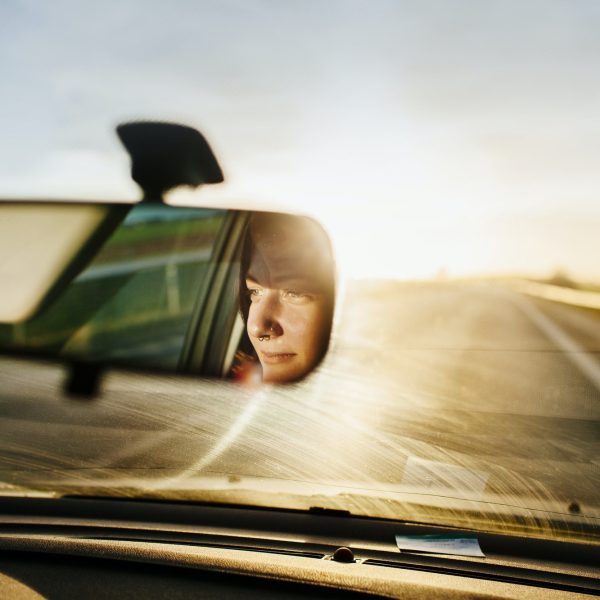 Reflection of woman in rear-view mirror